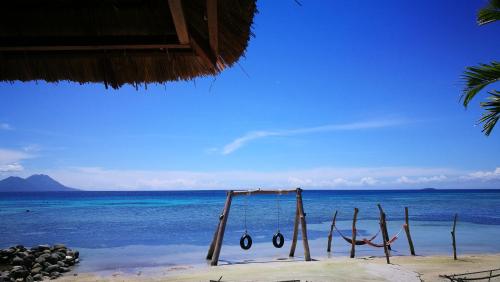 a swing on a beach near the ocean at Rapopo Plantation Resort in Kokopo