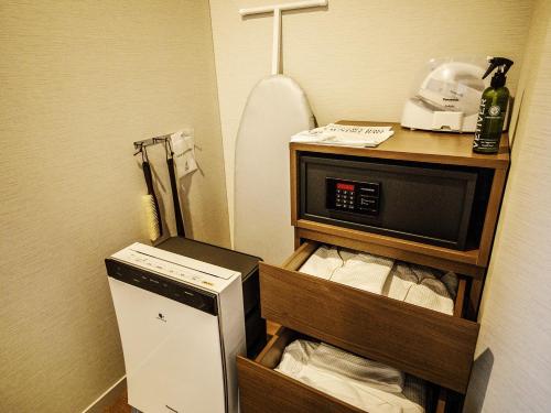 a small kitchen with a microwave and a refrigerator at Nagoya Prince Hotel Sky Tower in Nagoya