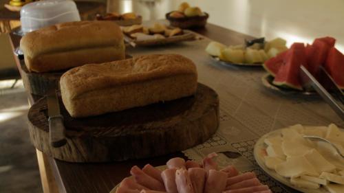 a table topped with plates of food and bread at Pousada Éden - Conforto, Imersão e Natureza in Sao Jorge