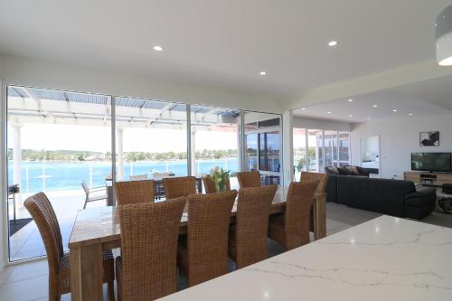 a dining room and living room with a table and chairs at Sybella in Merimbula
