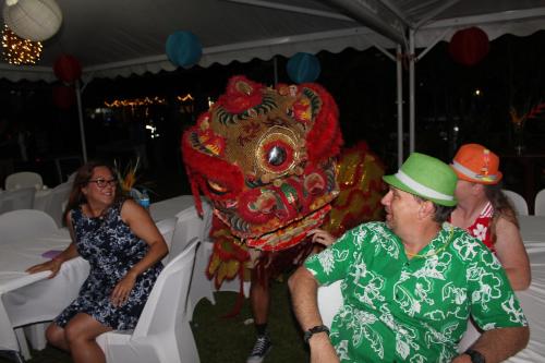 a man in a green hat standing next to a dragon costume at Rapopo Plantation Resort in Kokopo