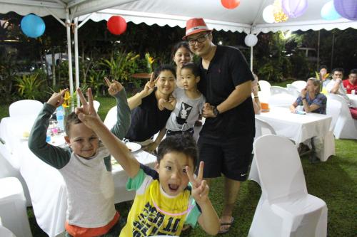 a man and children with their hands up at a party at Rapopo Plantation Resort in Kokopo
