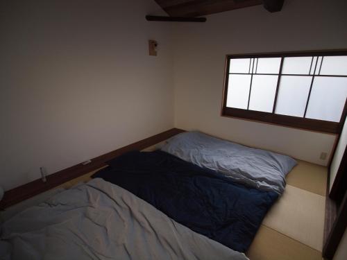 Un dormitorio pequeño con una cama y una ventana. en Kaika Minamino Ie, en Kioto