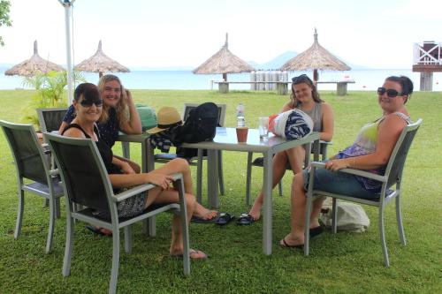 a group of women sitting at a table on the grass at Rapopo Plantation Resort in Kokopo