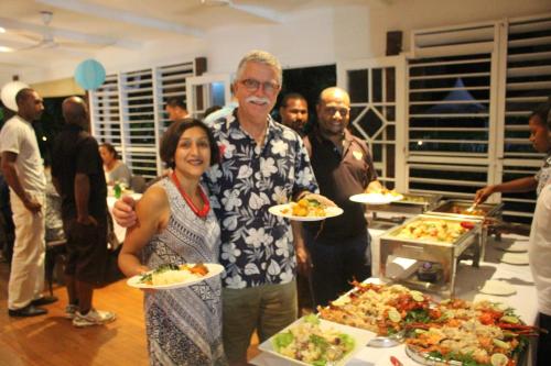 a man and a woman holding plates of food at Rapopo Plantation Resort in Kokopo