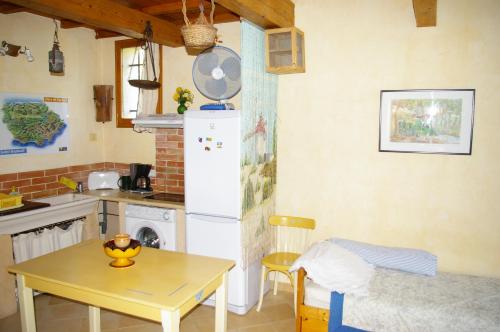 a kitchen with a table and a white refrigerator at Gite La Paillote in Montauroux