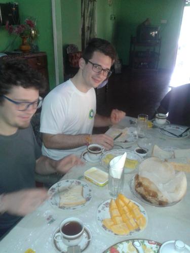 twee mannen aan een tafel met borden eten bij Parakum Rest Rooms in Polonnaruwa