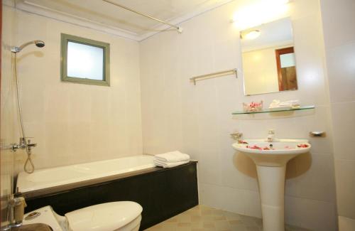 a bathroom with a toilet and a sink and a tub at Urban Alley Hotel in Hanoi