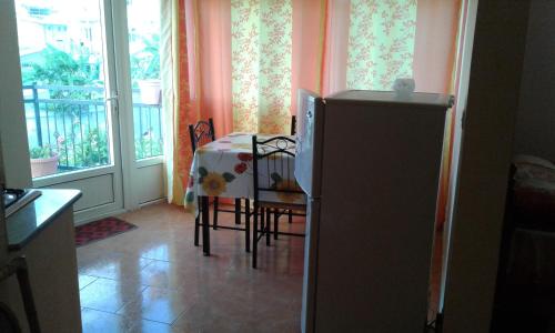 a kitchen with a table and a refrigerator and a window at Chetty Tourist Residence in Pereybere