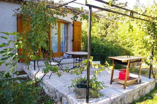 a patio with two tables and a pergola at Gite La Paillote in Montauroux