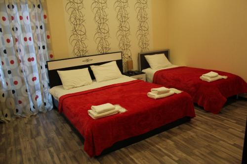 two beds in a hotel room with towels on them at ''Aragvi'' hotel in Naghorevi