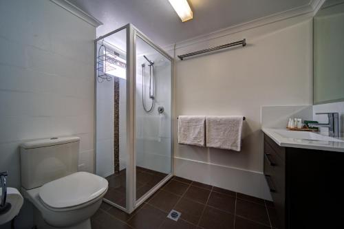 a bathroom with a shower and a toilet and a sink at Albacore Apartments in Merimbula