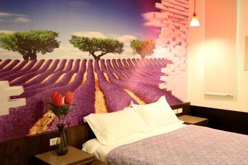 sypialnia z łóżkiem i obrazem przedstawiającym drzewa w obiekcie Outingfun Bed and Breakfast w mieście Jiaoxi