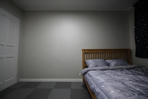 Un dormitorio con una cama con almohadas azules. en House of Forest en Chuncheon