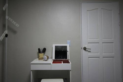 a white bathroom with a sink and a door at House of Forest in Chuncheon