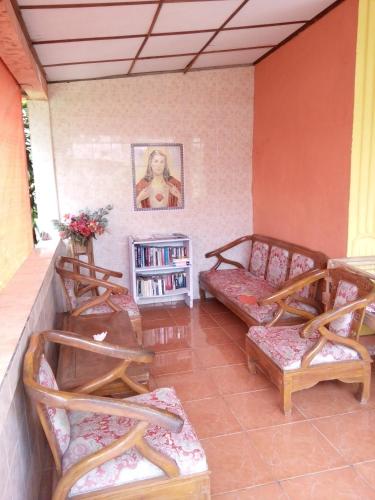 a living room with chairs and a book shelf at Novita Homestay in Bunaken