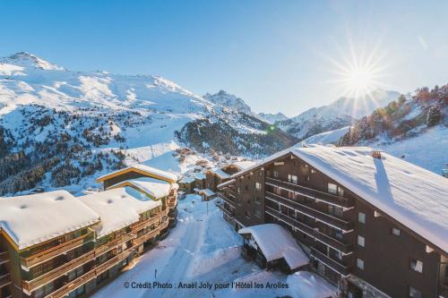 a view of a resort with snow covered mountains at Hotel Les Arolles in Méribel