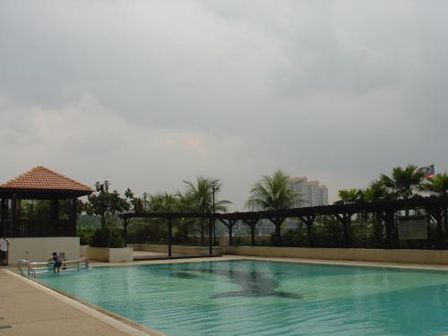 a large swimming pool in a resort with palm trees at Duta Hotel & Residence in Kuala Lumpur