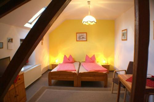 Habitación con 2 camas y almohadas rosas. en Pension Kronenburghof en Erfurt