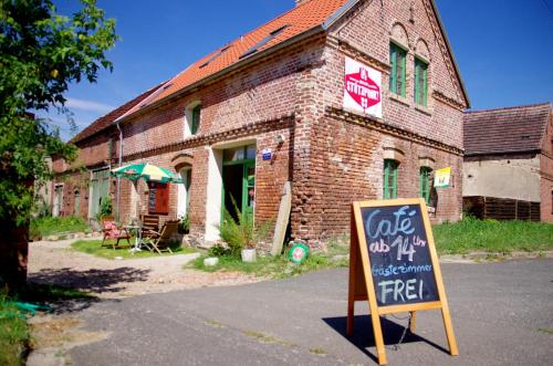 a brick building with a sign in front of it at Stützpunkt Trebitz - Gästezimmer am Europaradweg R1 in Brück