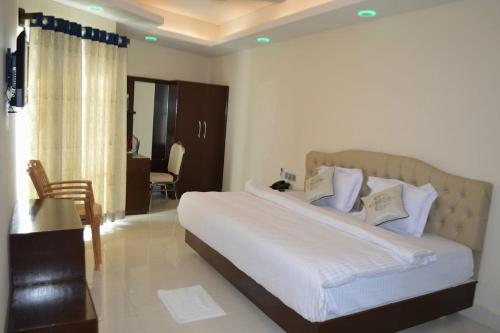 a bedroom with a large bed with white sheets and pillows at Exotica Sampan in Cox's Bazar