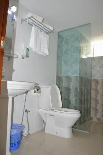 a bathroom with a white toilet and a sink at Exotica Sampan in Cox's Bazar