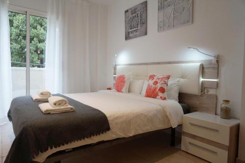 a bedroom with a large bed with towels on it at Matilda Home on the Beach in Sitges