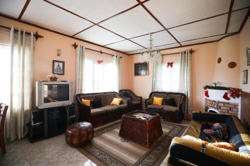 a living room with a couch and a tv at Pedro View Homestay in Nuwara Eliya