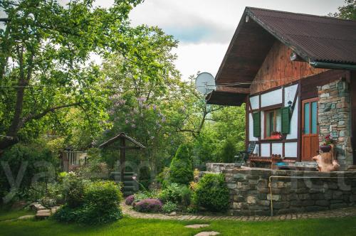 a house with a dog sitting outside of it at садиба "У Чубчика" in Yaremche