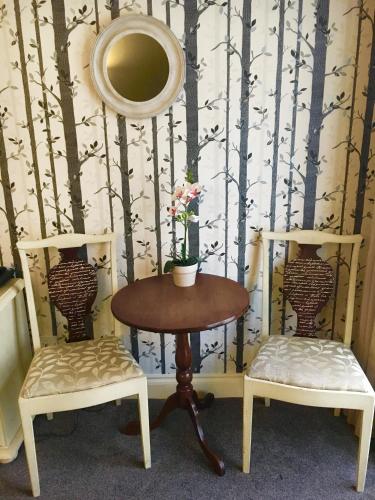 a table and two chairs with a table and a mirror at Normanton Park Hotel, Sure Hotel Collection by Best Western in Oakham