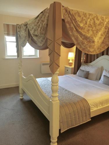 a bedroom with a bed with a canopy at Normanton Park Hotel, Sure Hotel Collection by Best Western in Oakham