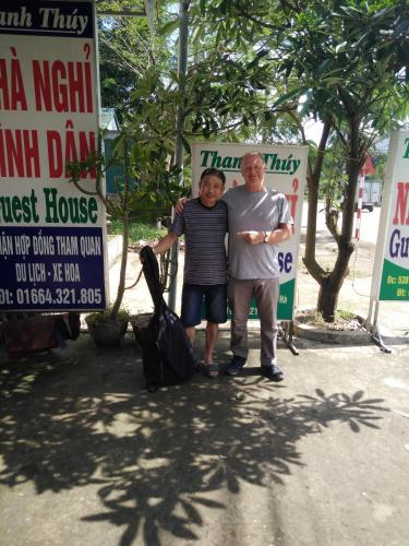 a man and a woman standing in front of signs at Thanh Thúy Guesthouse in Ðông Hà