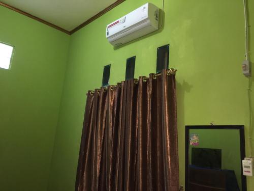 a green room with a air conditioner on the wall at Aini Home Stay in Ternate