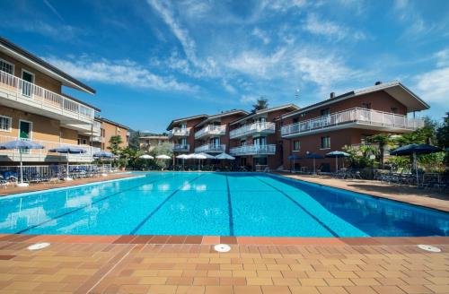 a swimming pool at a resort with chairs and umbrellas at Residence Villa Rosa in Garda