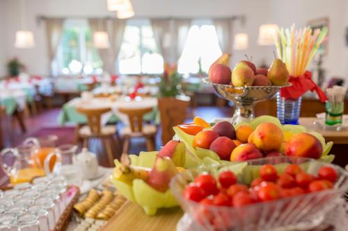 uma mesa coberta com tigelas de frutas e snacks em Villa Konstanze em Velden am Wörthersee