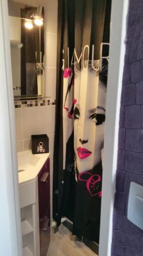 une salle de bains avec une grande peinture de femme dans l'établissement Naturiste Port Soleil, au Cap d'Agde