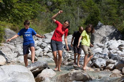 a group of people walking on rocks in the water at Ferienwohnung Biechl-Hauser Doris in Sankt Ulrich am Pillersee