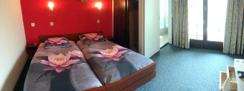 ein Schlafzimmer mit 2 Betten mit Blumen drauf in der Unterkunft Hôtel de Ville in Broc