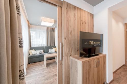 a living room with a tv and a couch at Hotel Mondin in Ischgl