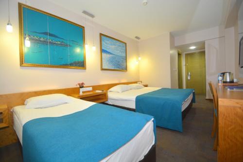a hotel room with two beds and a table at Istankoy Hotel in Kusadası