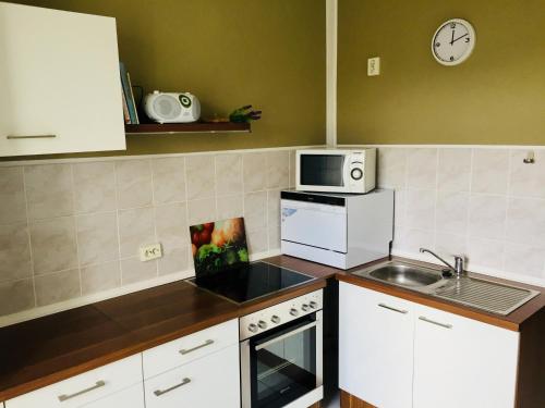 a kitchen with white cabinets and a microwave and a sink at Ferienwohnung Tiffy in Chemnitz