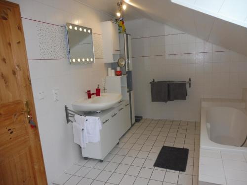 a white bathroom with a sink and a toilet at Ferienwohnung am Fuß des Bayerischen Waldes in Wörth an der Donau