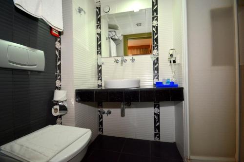 a bathroom with a sink and a toilet at Istankoy Hotel in Kusadası