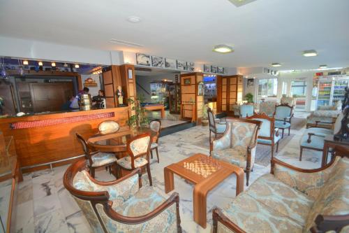 a lobby with chairs and tables and a bar at Istankoy Hotel in Kusadası