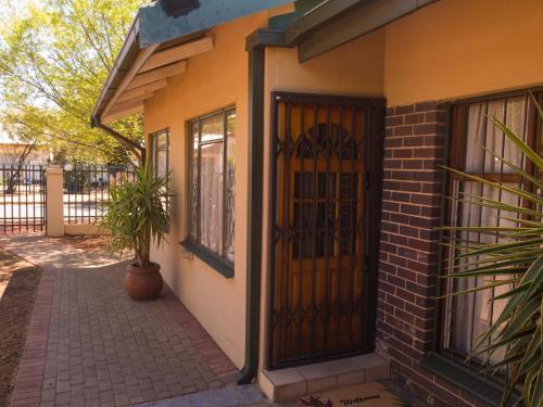 a front door of a house with a potted plant at PureJoy Self-Catering Accommodation in Bloemfontein