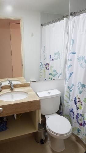 ein Badezimmer mit einem WC, einem Waschbecken und einem Duschvorhang in der Unterkunft Laguna Bahía, Algarrobo in Algarrobo