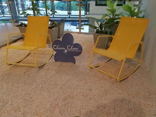 two yellow chairs sitting on top of a carpet at Hotel Chuan Chom The High Resort Saraburi - SHA Plus in Sara Buri