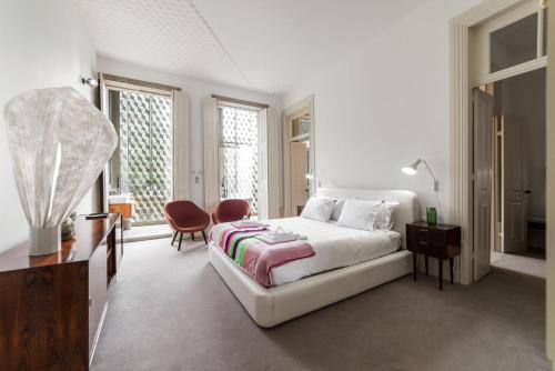 a white bedroom with a bed and two chairs at Malmerendas Boutique Lodging in Porto
