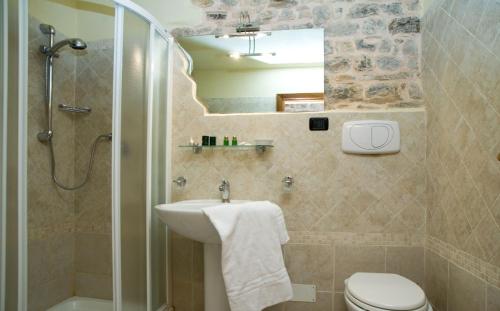 a bathroom with a sink and a shower and a toilet at Appartamento San Martino in Spoleto