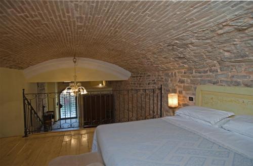 a bedroom with a bed and a stone wall at Appartamento San Martino in Spoleto